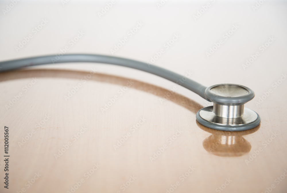 Close up view of grey stethoscope on brown background. Close up view of grey stethoscope on brown background.