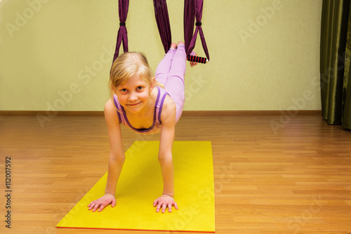 Little girl making aerial yoga exercises, indoor