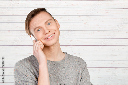 Young smiling man talking on the mobile phone
