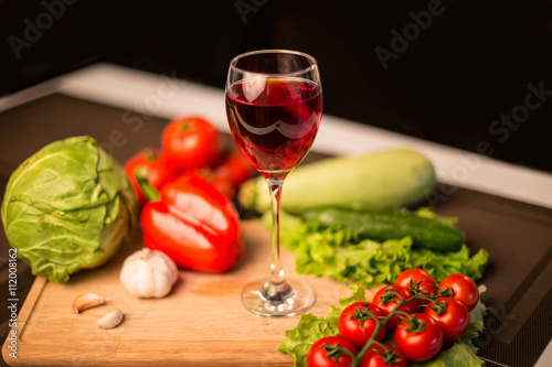 Glass of red wine and fresh salad vegetables