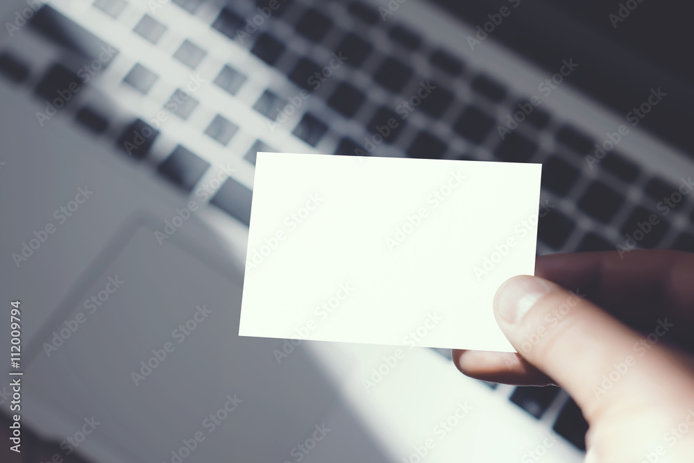 Closeup Image Man Showing Blank White Business Card and Using Modern Laptop Blurred Background. Mockup Ready for Private Information. Sunlight Reflections Surface Gadget. Horizontal mock up. Closeup Image Man Showing Blank White Business Card and Using Modern Laptop Blurred Background. Mockup Ready for Private Information. Sunlight Reflections Surface Gadget. Horizontal mock up.