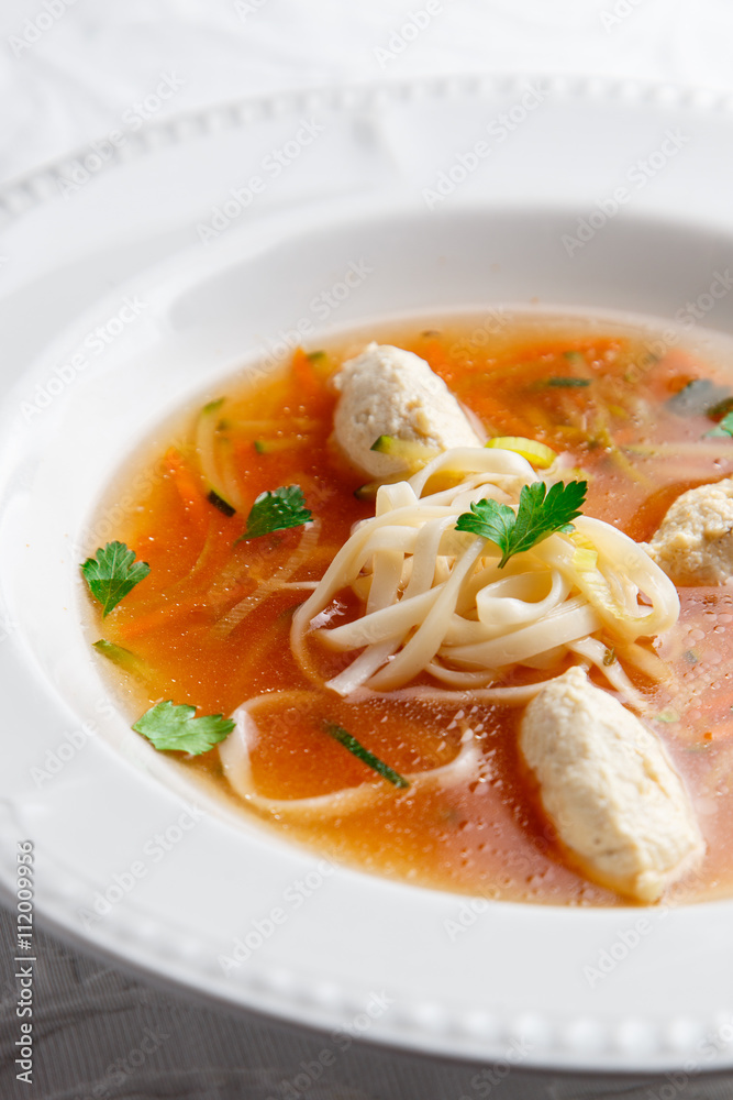 Chicken soup with noodles and vegetables in white bowl Chicken soup with noodles and vegetables in white bowl