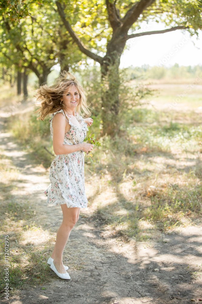 Girl jumping, dancing, spinning in an oak alley. The wind blew her hair and dress. Bright and sunny picture.Fain art film. Girl jumping, dancing, spinning in an oak alley. The wind blew her hair and dress. Bright and sunny picture.Fain art film.