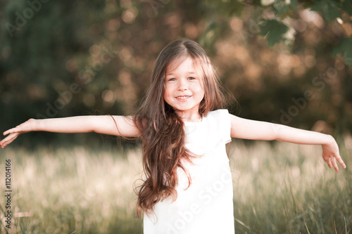 Smiling kid girl having fun outdoors. Looking at camera. Laughing kid. Childhood.