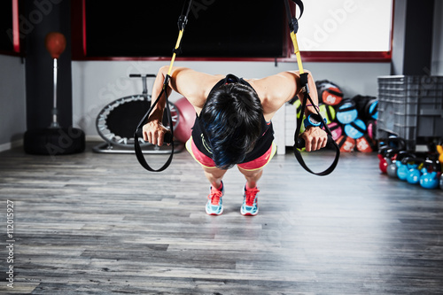 ragazza trx in palestra allenamento gambe photo
