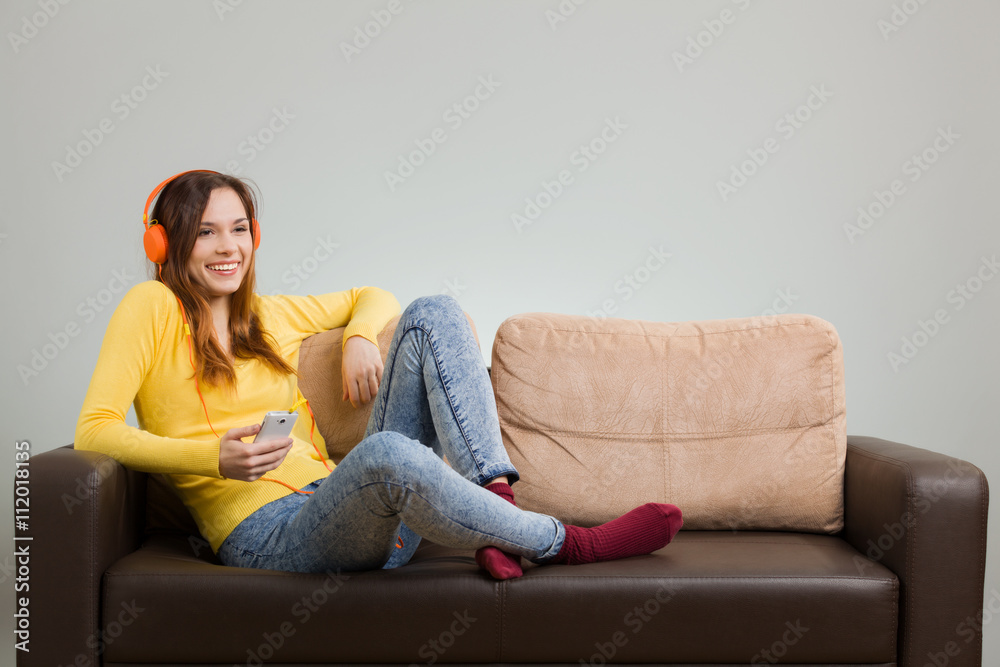 Obraz premium Young woman listening music from her smartphone.