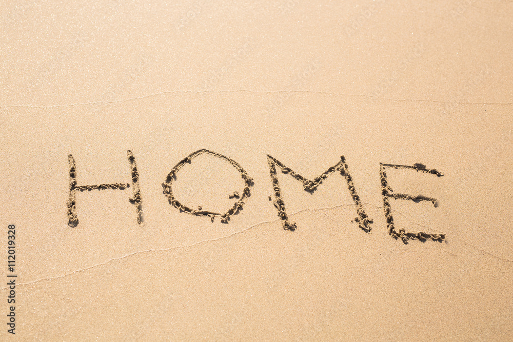 word home written in sand on beach word home written in sand on beach