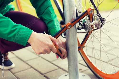Canvas-taulu close up of man fastening bicycle lock on parking