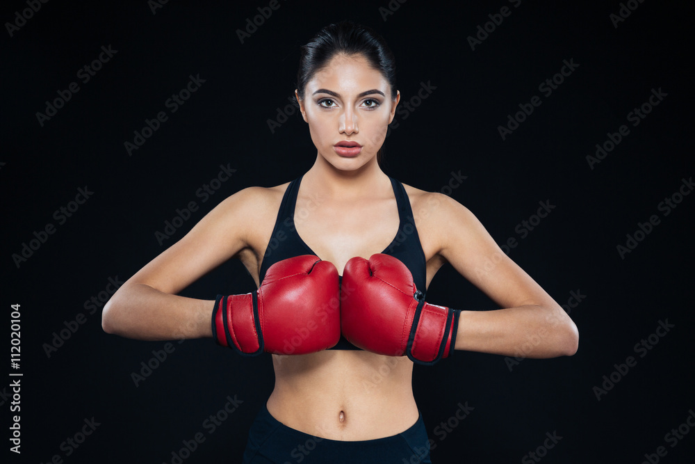 Young fitness girl with bloxing gloves looking at camera