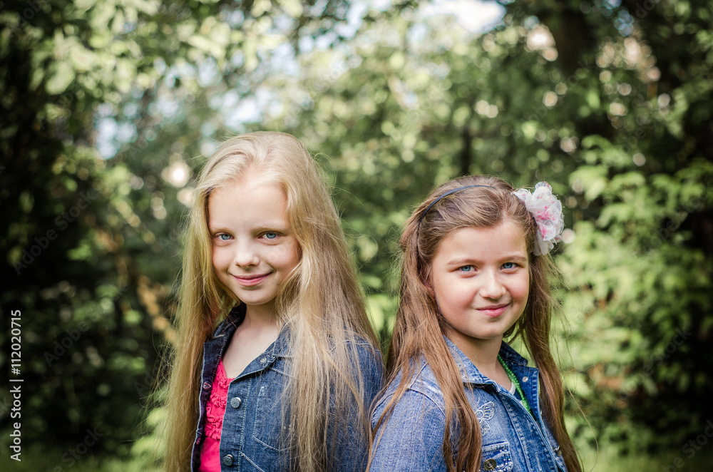 Portrait of two long haired preteen girls while smiling. Stock 写真 | Adobe Stock