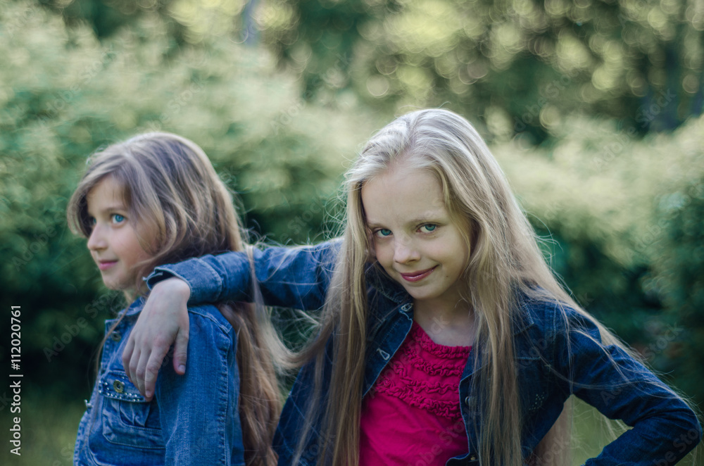 Portrait of two cute little girls enjoying summer outdoors. Portrait of two cute little girls enjoying summer outdoors.