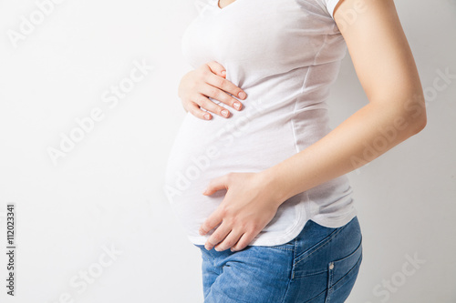 Unrecognizable pregnant woman embracing belly © julenochek