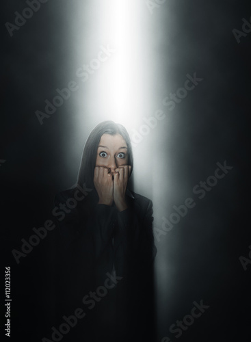 Petrified woman standing in a beam of light photo