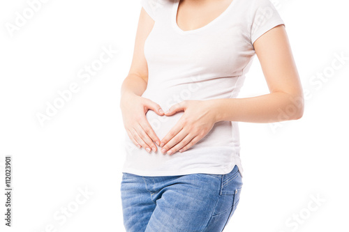 Close-up of pregnant woman embracing belly with heart shape © julenochek