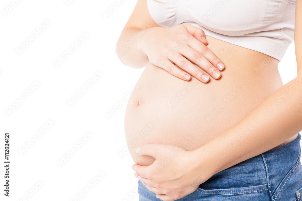 Unrecognizable pregnant woman embracing her belly