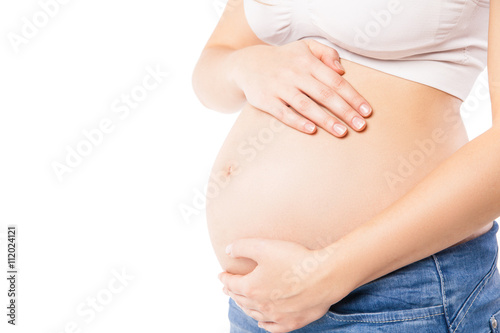Unrecognizable pregnant woman embracing her belly