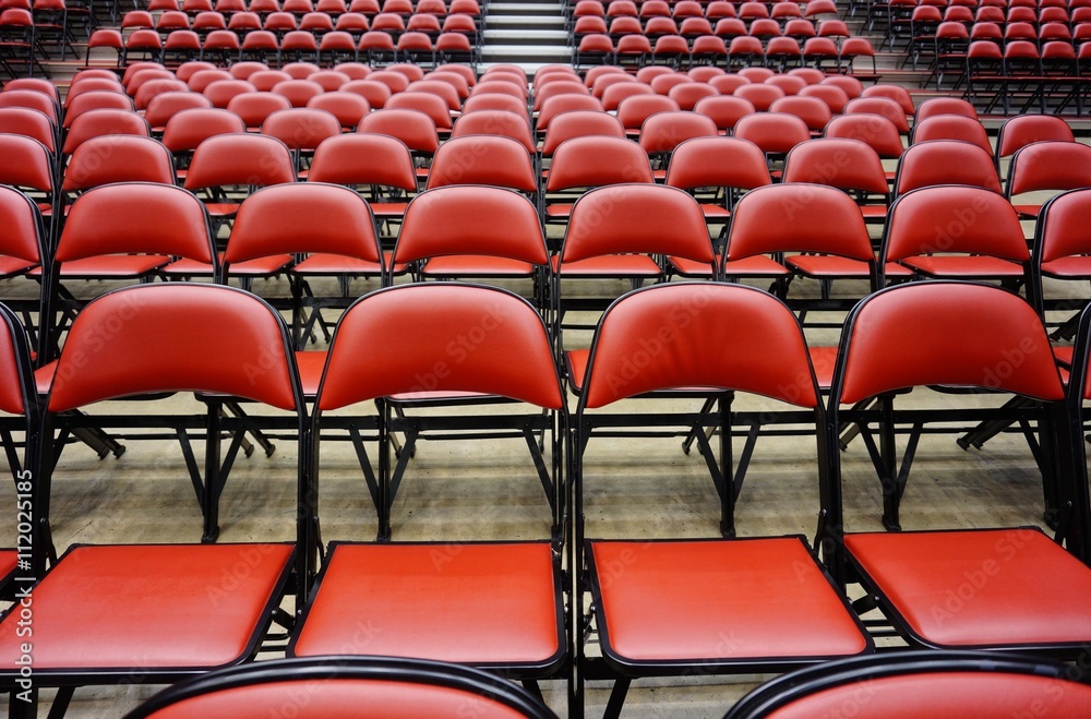 Fototapeta premium Folded red seats at a multipurpose arena and sports stadium