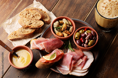 Tapas of salmon, mussels, jamon and olives with beer