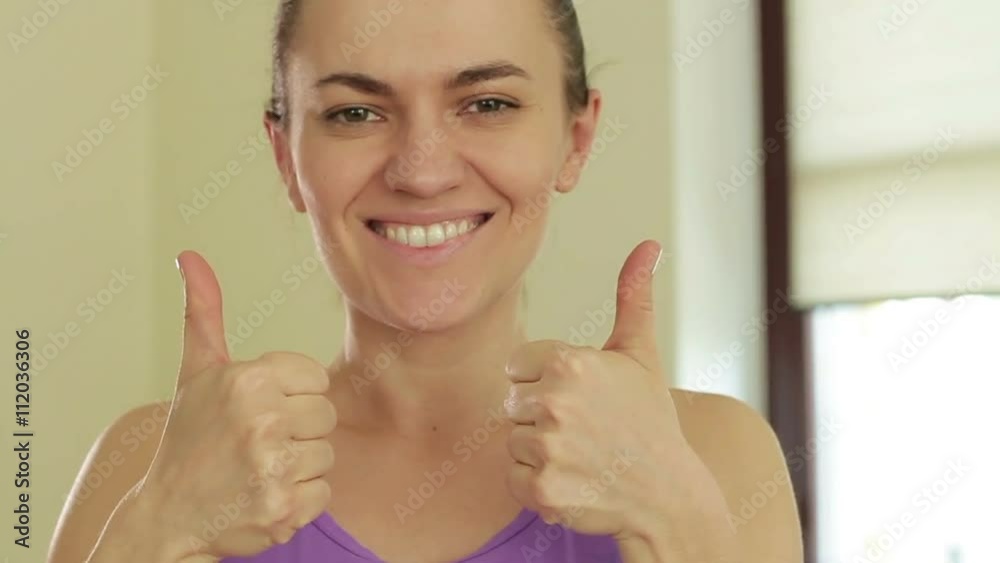 Portrait of young smiling sporty woman with thumbs up, slow motion Portrait of young smiling sporty woman with thumbs up, slow motion
