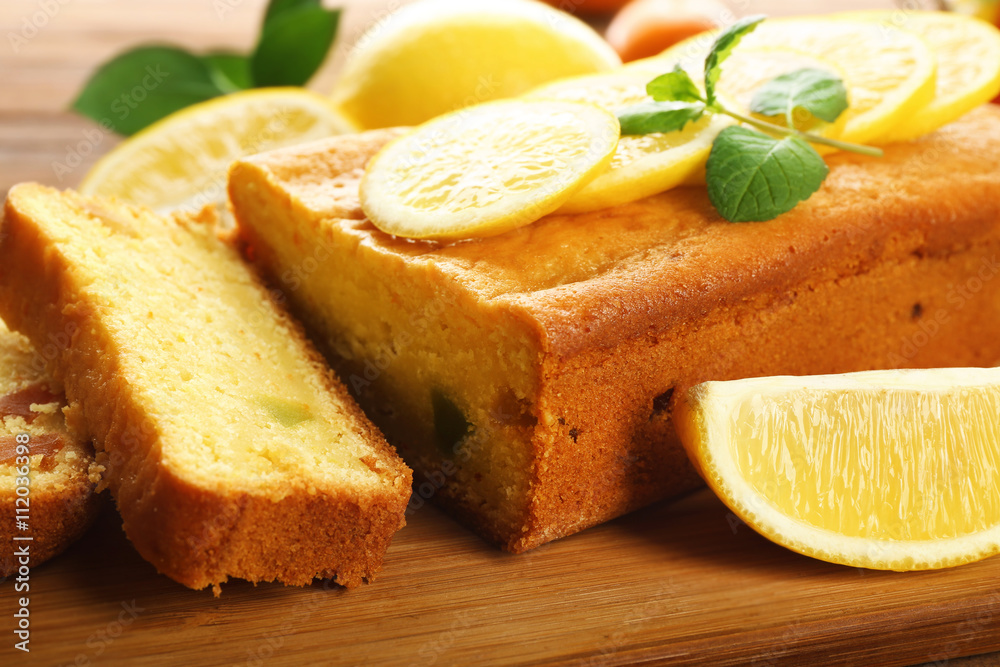 Delicious citrus cake loaf with lemons on wooden board