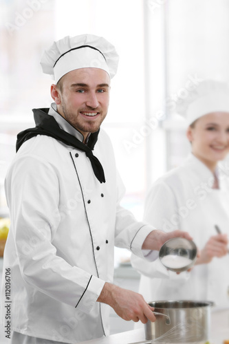Male and female chefs worki...
