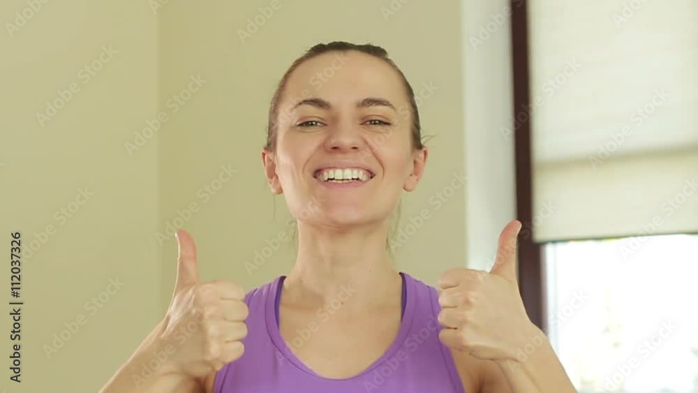 Portrait of young smiling sporty woman with thumbs up, slow motion Portrait of young smiling sporty woman with thumbs up, slow motion