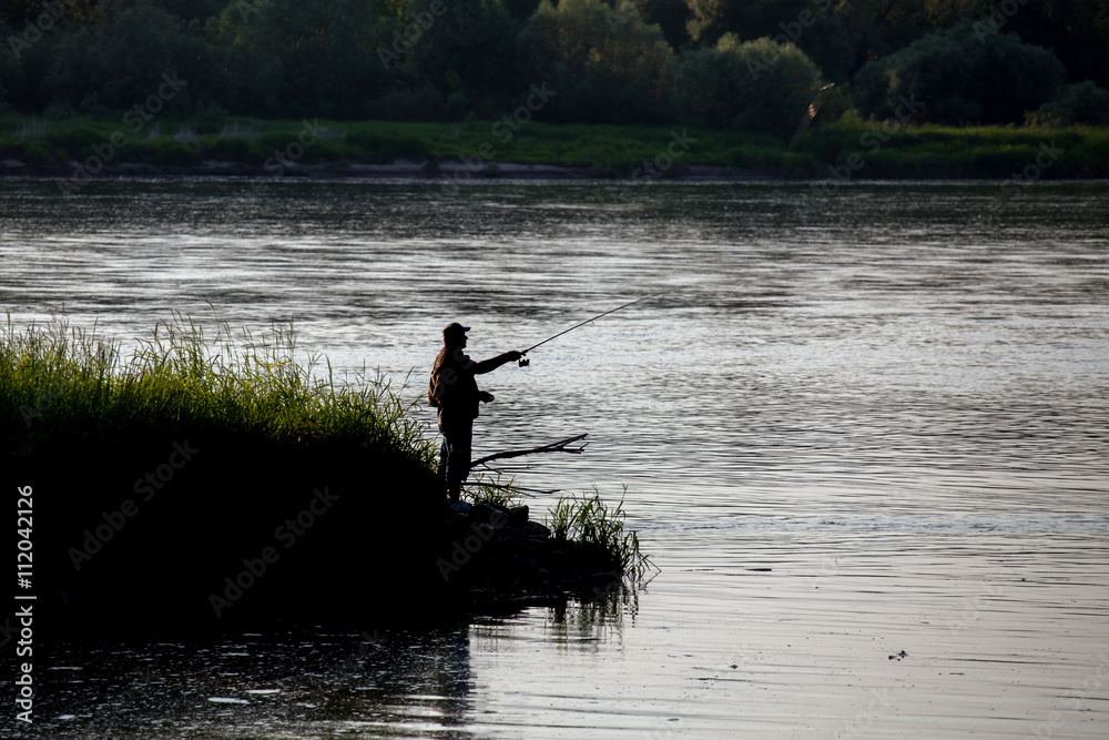 Fisherman fishing on river , angler at sunset 
