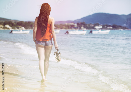 Woman walking on sandy beach Laganas Zakynthos Greece
