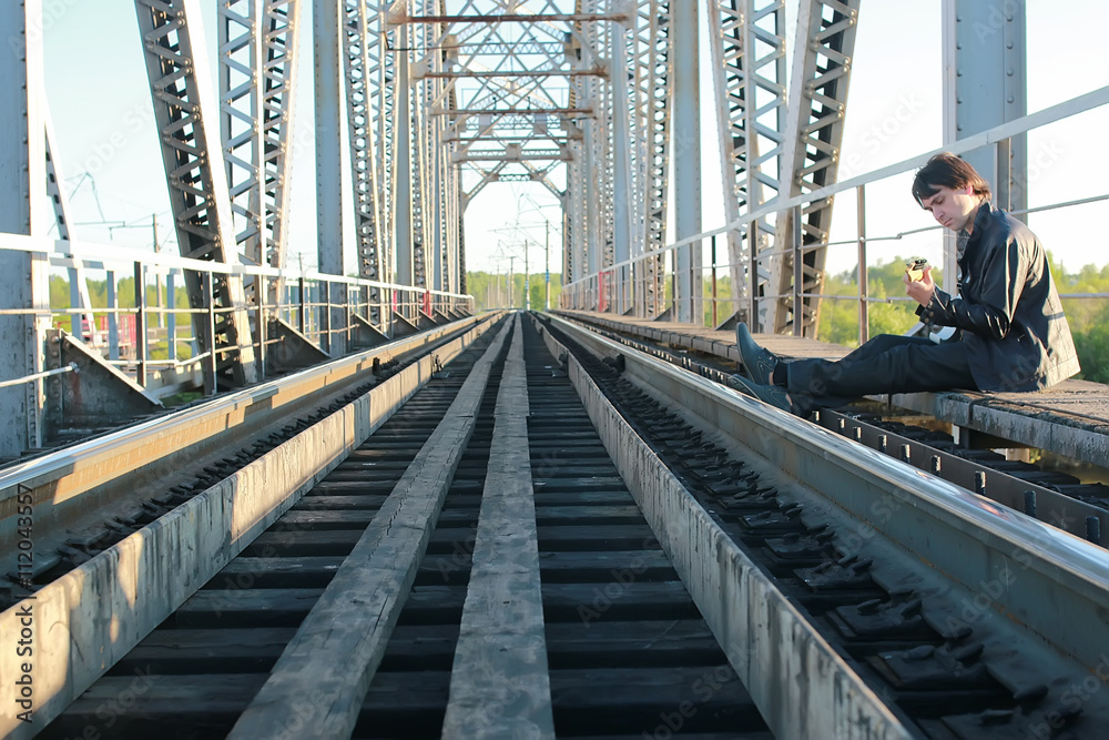 man with a guitar on a railroad