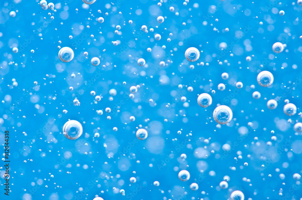 Close-up bubbles under water on blue background. Macro.