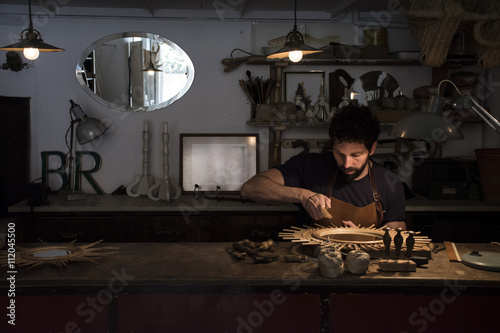 Craftsman manufacturing a mirror in his workshop photo