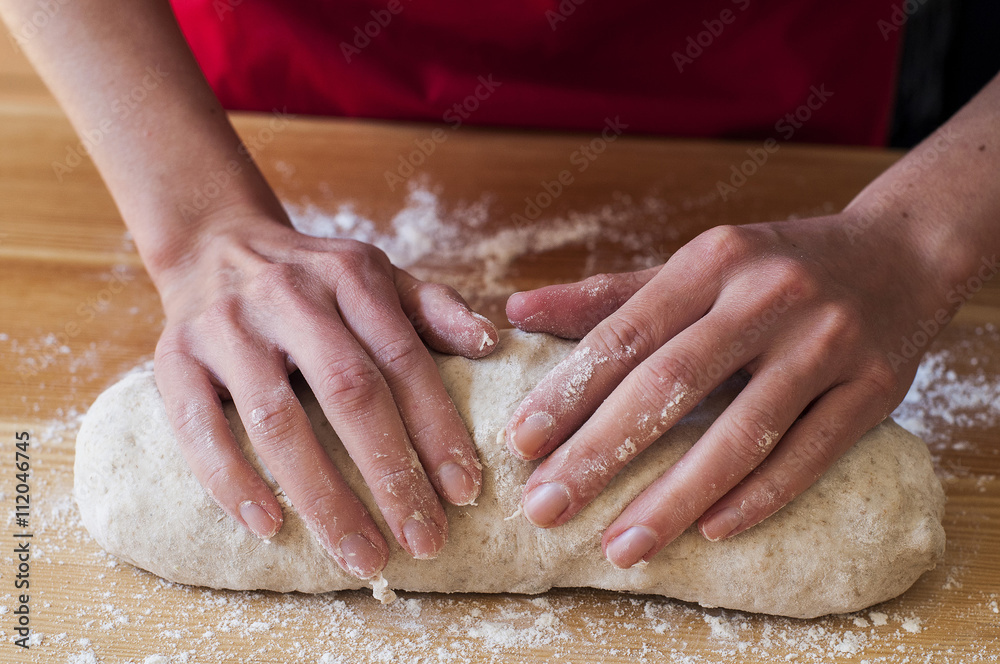Preparing bread at home: woman hands kneading dough