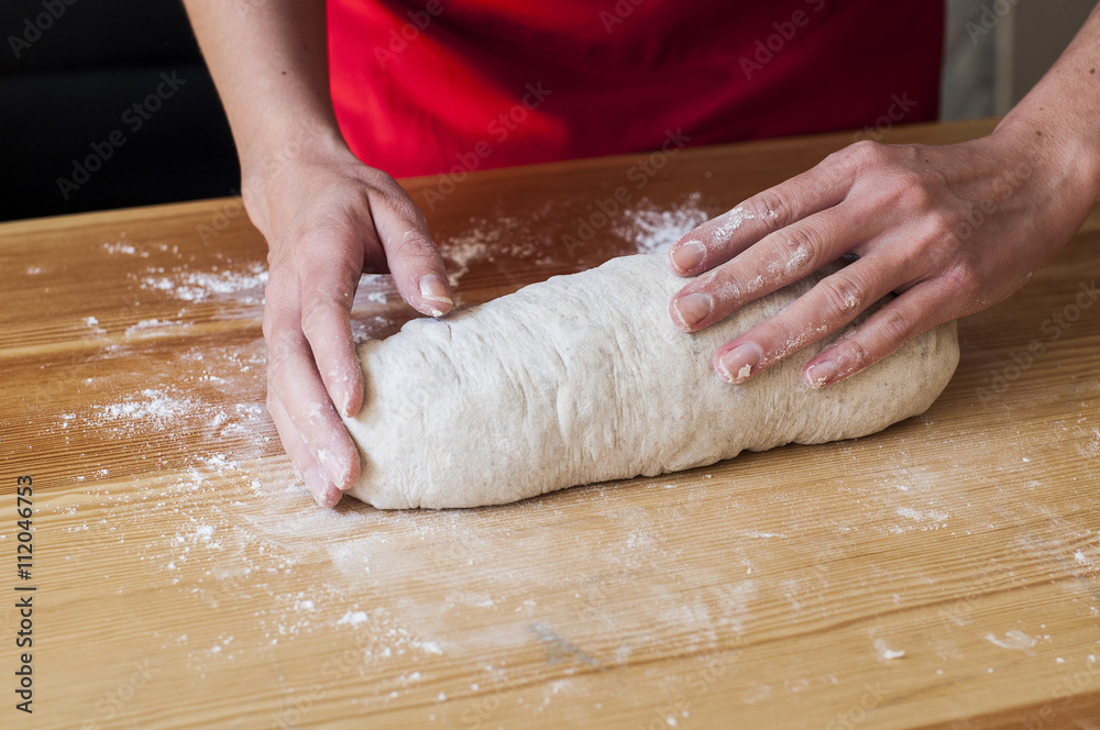 Preparing bread at home: woman hands kneading dough