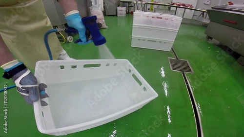 Hygiene and Disinfection in Meat Industry / Man using high pressure water and specially formulated cleaning agents for cleaning container in meat processing factory HD1080p