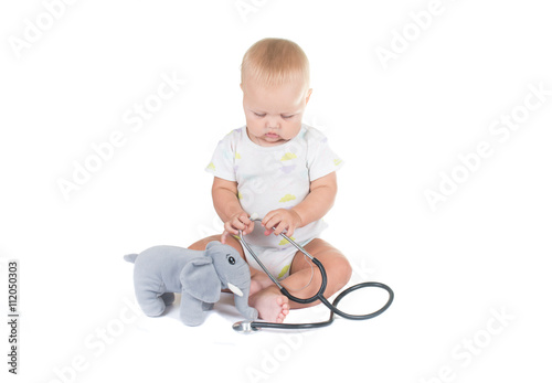 Adorable child dressed as doctor playing with toy Isolated on white background © lexmomot
