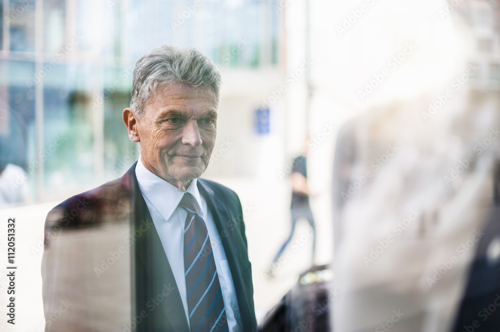 Senior man in suit looking at shop window Senior man in suit looking at shop window