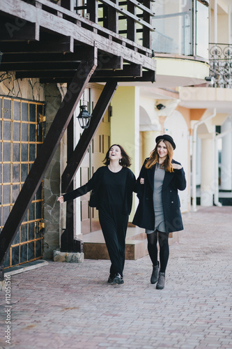 Two young women friends walking on a street