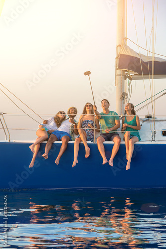 People taking selfies on yacht. Smiling men and women. Weekend with friends. Living the dream. © DenisProduction.com