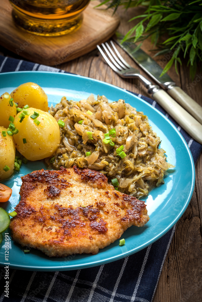 Fried pork chop, baked potatoes and fried young cabbage. Fried pork chop, baked potatoes and fried young cabbage.