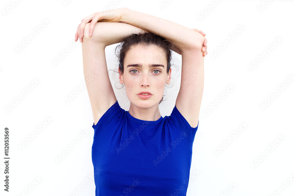 Serious young woman staring with arms above her head Serious young woman staring with arms above her head