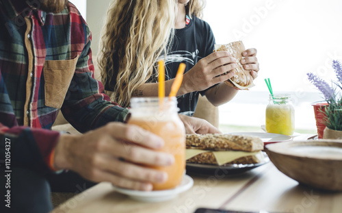 Couple having breakfast in cafe, drinking organic juices photo