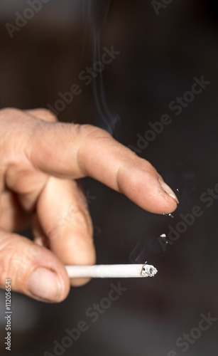 smoking a cigarette in his hand on black