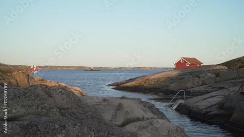 Red cottage and lifebuoy on the Swedish west coast (district Bohuslan). photo