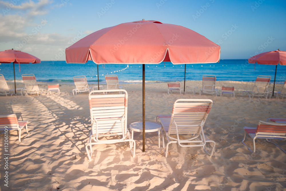 Tropical empty sandy beach with umbrella and chairs