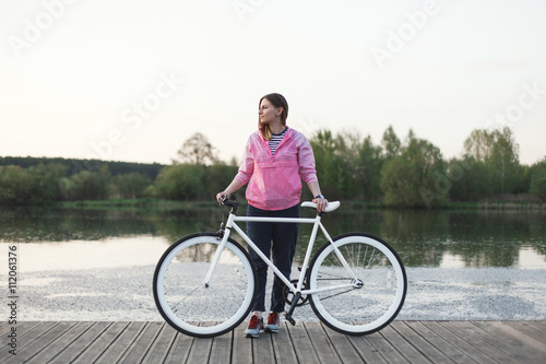 Hipster girl stand with bicycle