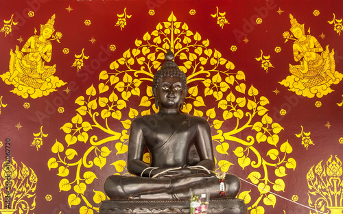 Statue of buddha with mural background