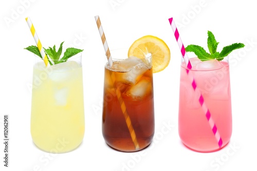 Three rounded glasses of summer lemonade, iced tea, and pink lemonade drinks with straws isolated on a white background