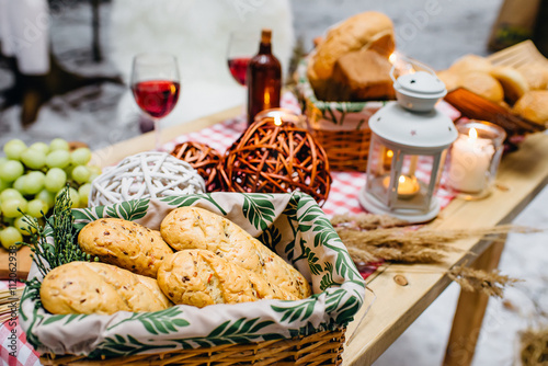 table with baskets of cookies and bread, wine, candles