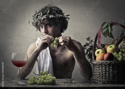Bacchus holding a bunch of grapes photo
