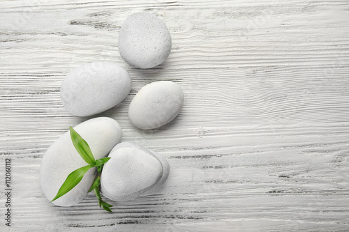 Heap of spa hot stones on white wooden background